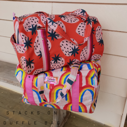 Two Stacks On Duffle Bags on top of each other, sitting on a timber bench with a white background.